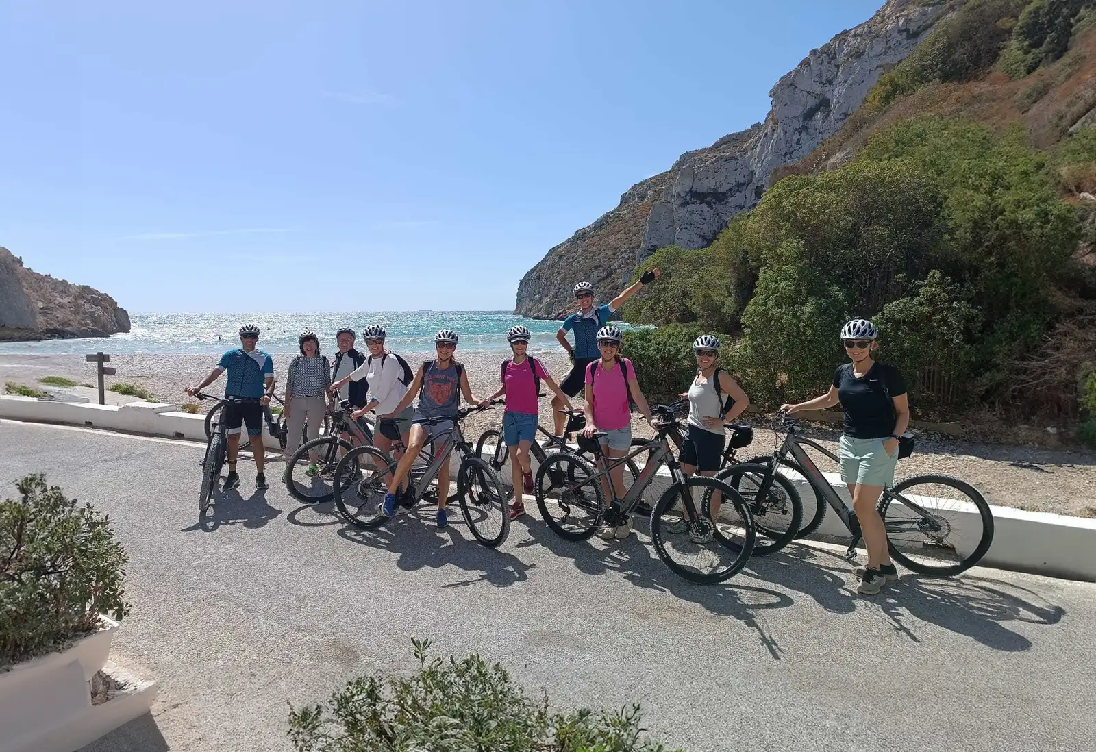 Grupo de personas en una ruta en bicicleta junto a la costa disfrutando de una experiencia de aventura al aire libre