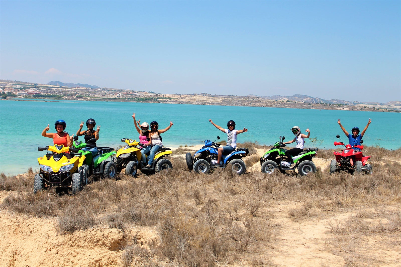 Equipo de trabajo disfrutando de una excursión en quads por un sendero costero como actividad de team building al aire libre